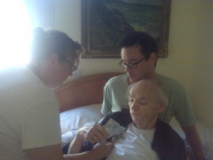 My DS and DB caring for Dad who is so ill he can't sit up.  DB is supporting Dad with his Body.  While DS is taking Dad's temp.  